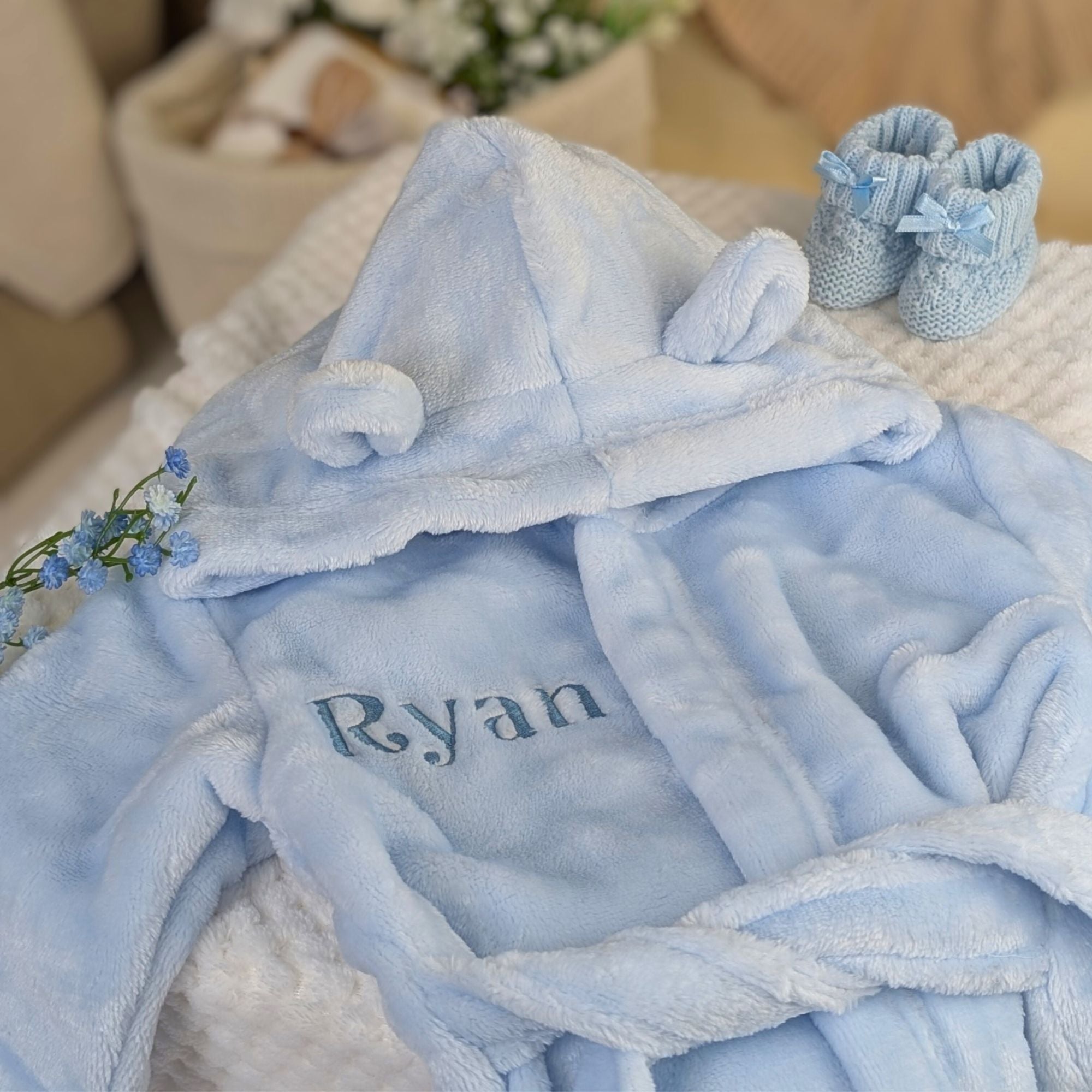 Personalised baby dressing gown in blue with custom name embroidered on the right and little ears on the hood.
