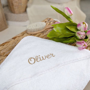 white personalised baby hooded towel with the name oliver embroidered on the hood