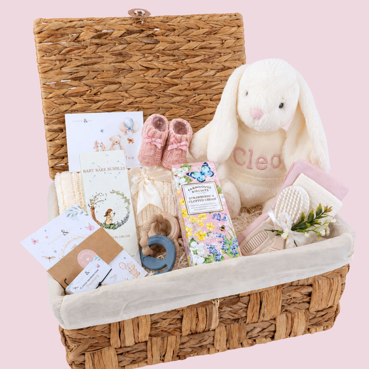 Personalised baby girl gift hamper in a basket with cream bunny rabbit with cleo embroidered on it's jumper, blanket and gifts for the parents too.