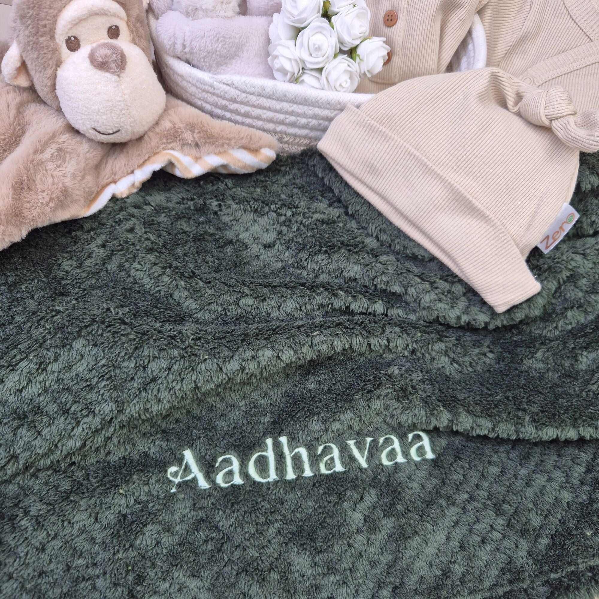 Personalised baby blanket in dark green waffle with embroidered name.