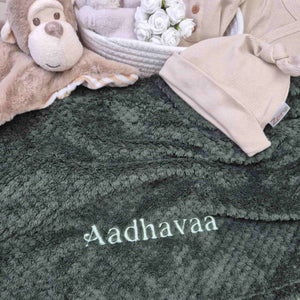 Personalised baby blanket in dark green waffle with embroidered name.