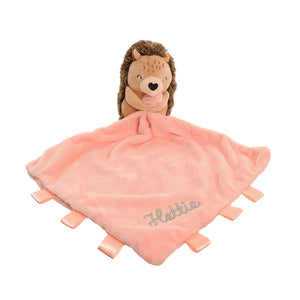 Plush hedgehog toy with a pink blanket labeled 'Hettie' on a white background