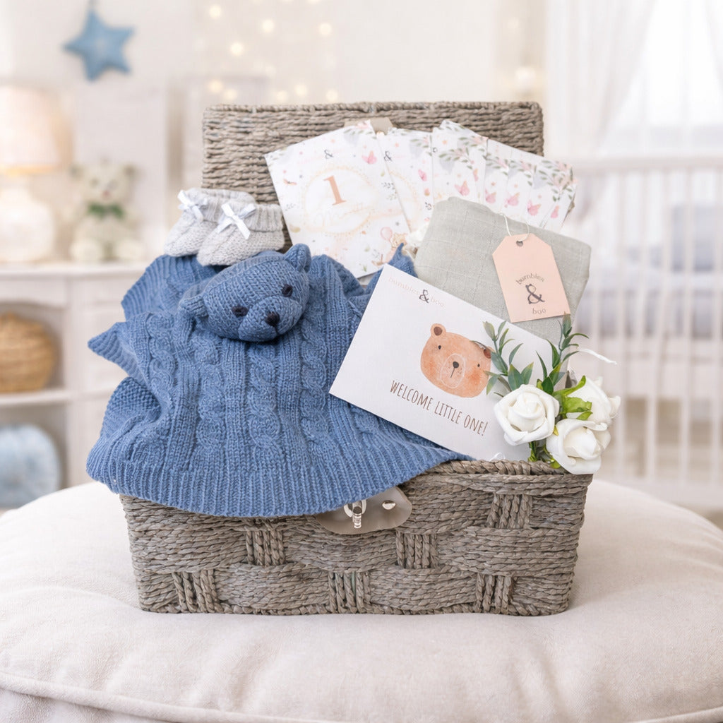 A hamper basket gift including a blue bear comforter and cotton muslins.