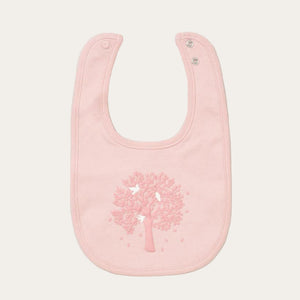 Pink baby bib with tree design.