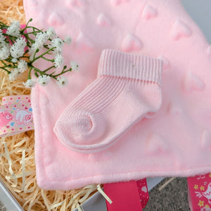 pink baby socks on pink taggie comforter for baby girl