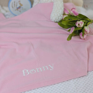 A personalised and pink baby fleece blanket.