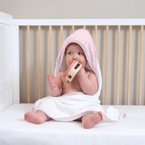 Pink and white baby towel for bath time with a hood.