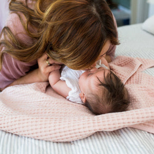 pink waffle baby blanket shown with mum and baby.
