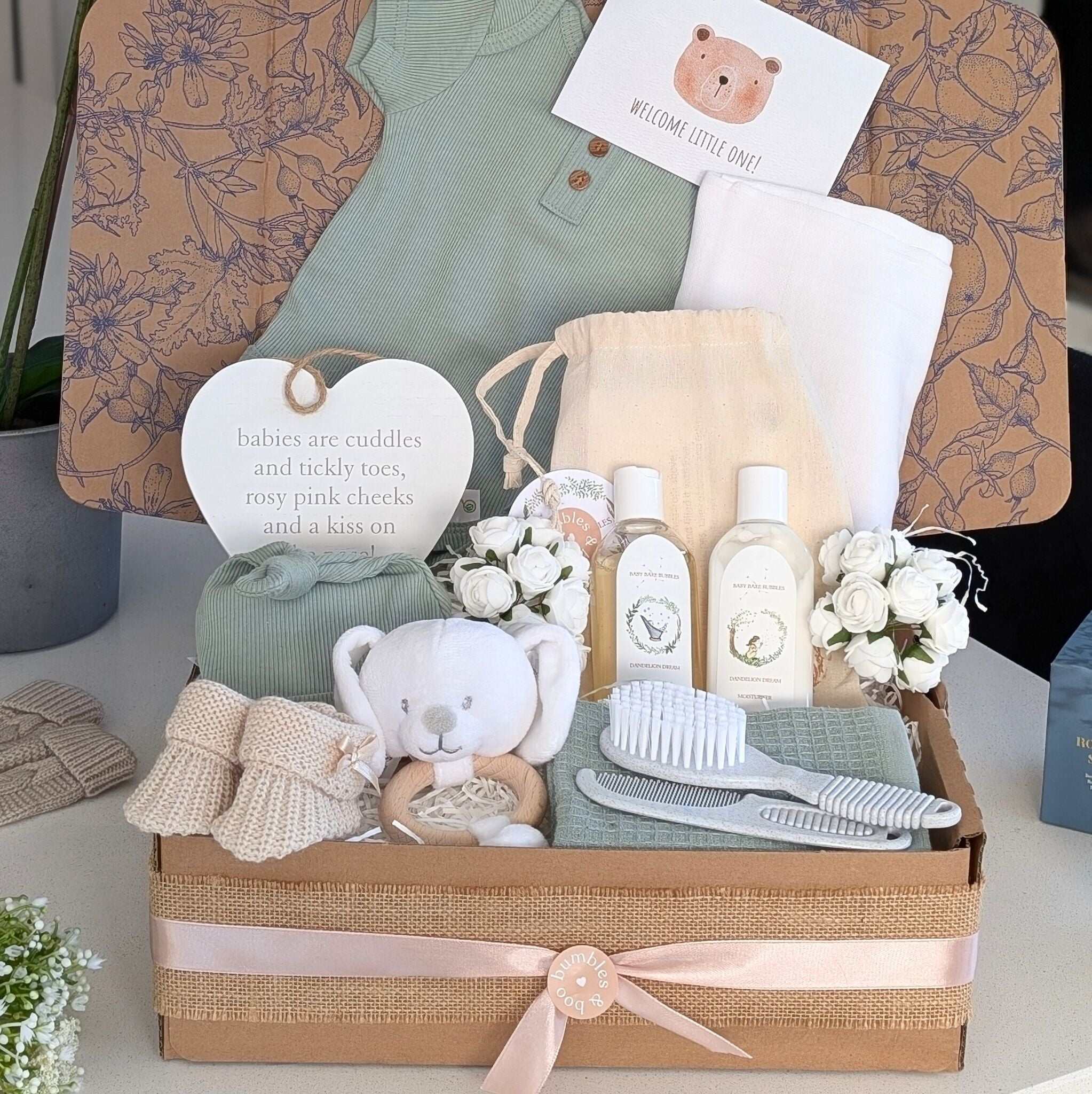 New baby gift box by Bumbles and Boo. Presents in this gift hamper are white and sage green and neutral colours.