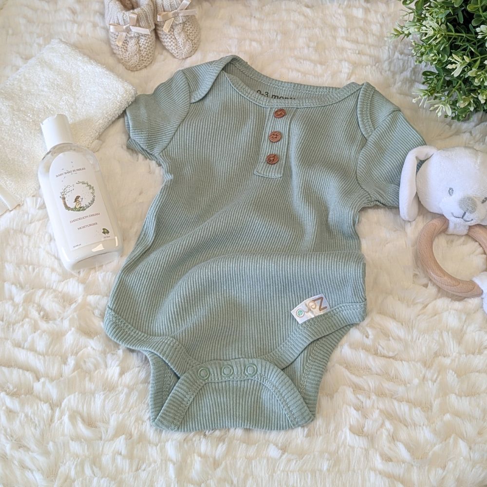 Green baby body vest with buttons.