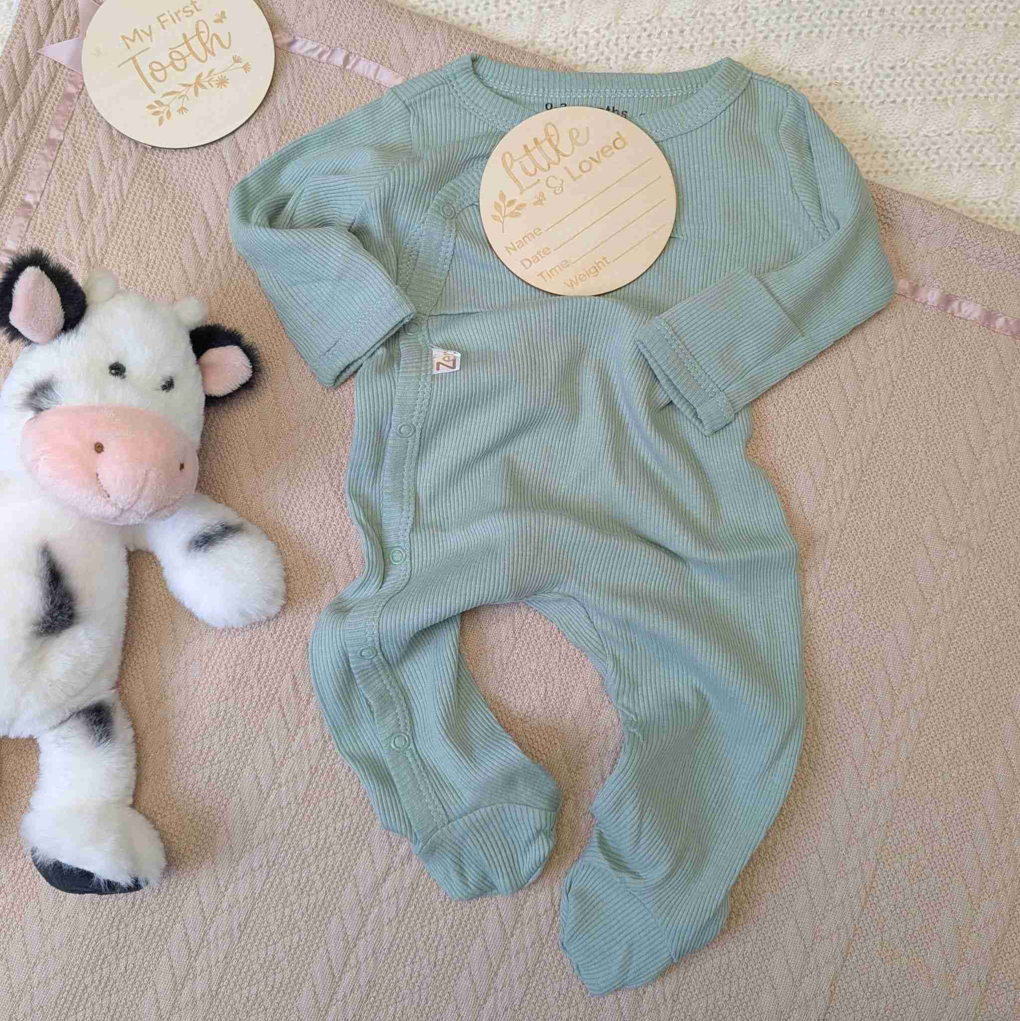 Sage green ribbed baby sleepsuit with poppers and a ribbed design.