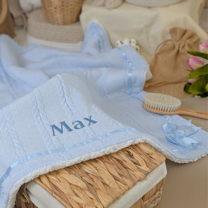 A blue baby blanket which can be personalised with baby's name with a bow.