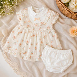 Baby girl clothing outfit of a dress and under pants. In Beige with a floral pattern