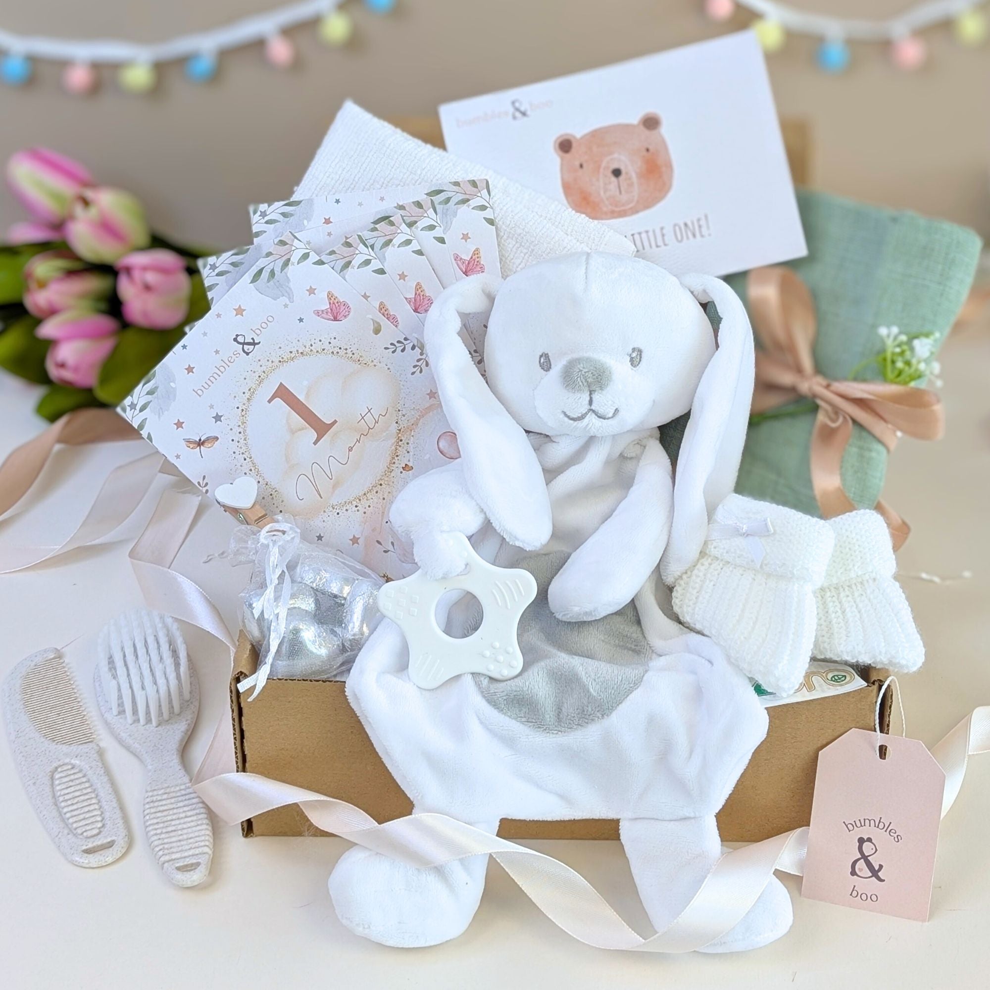 New baby gifts box by Bumbles and Boo. This hamper features a white bunny comforter and presents for a newborn. Bumbles and Boo.