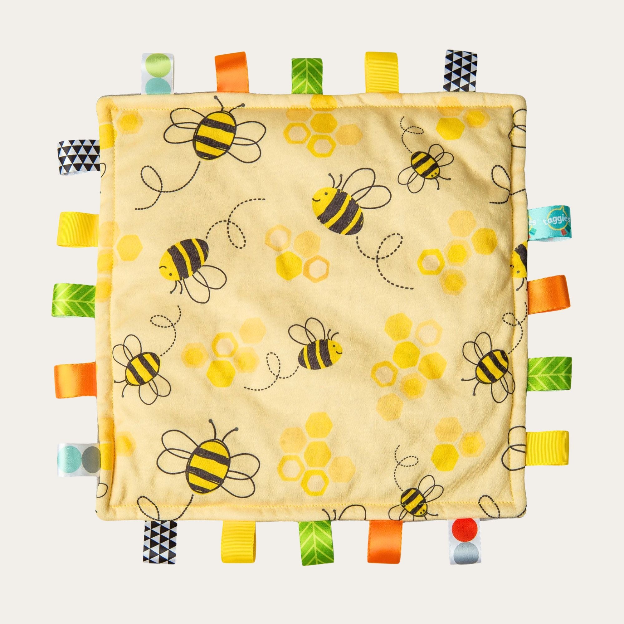 Yellow taggie toy baby comforter with tags in bee print design.