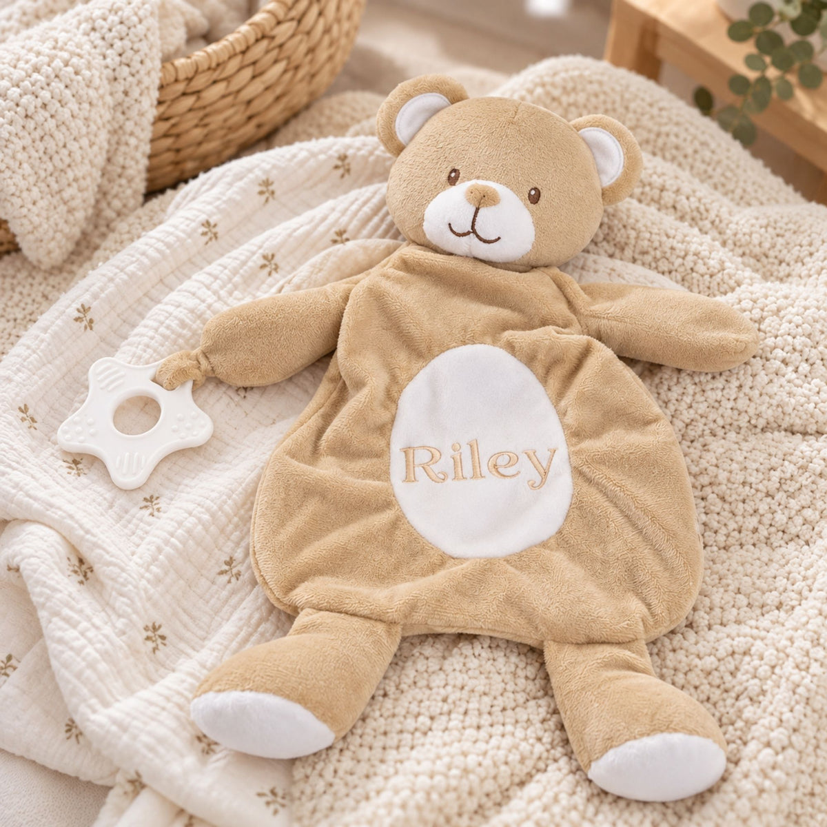 Personalised baby comforter in a beige bear design with a custom name across the tummy and teething toy attached.