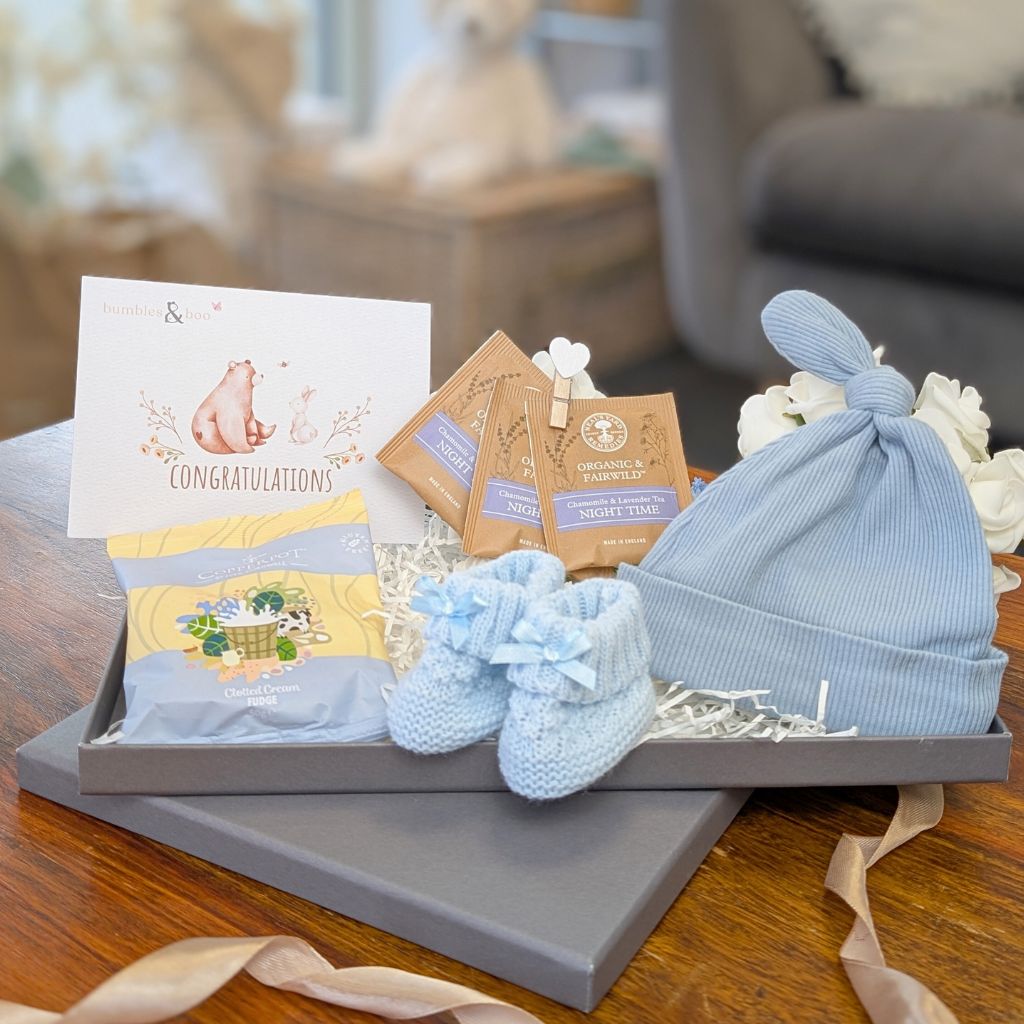 New mum letterbox gifts box with blue hat and baby essentials.