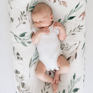 Bamboo swaddle blanket with leaf print pattern for a baby.