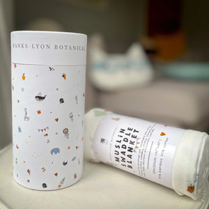 Muslin swaddle blanket presented in a cardboard tube