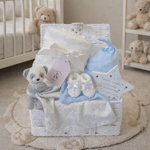 Unique baby boy gifts in a white hamper basket with blanket, blue hat and panda bear newborn comforter.