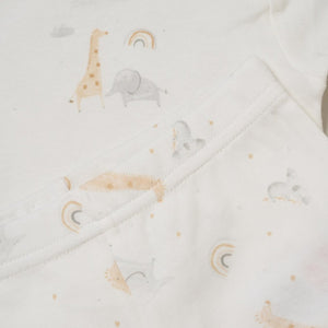 Close up of giraffe elephant and rainbow print on cream fabric