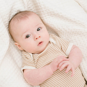 waffle baby blanket in cream, shown with baby.