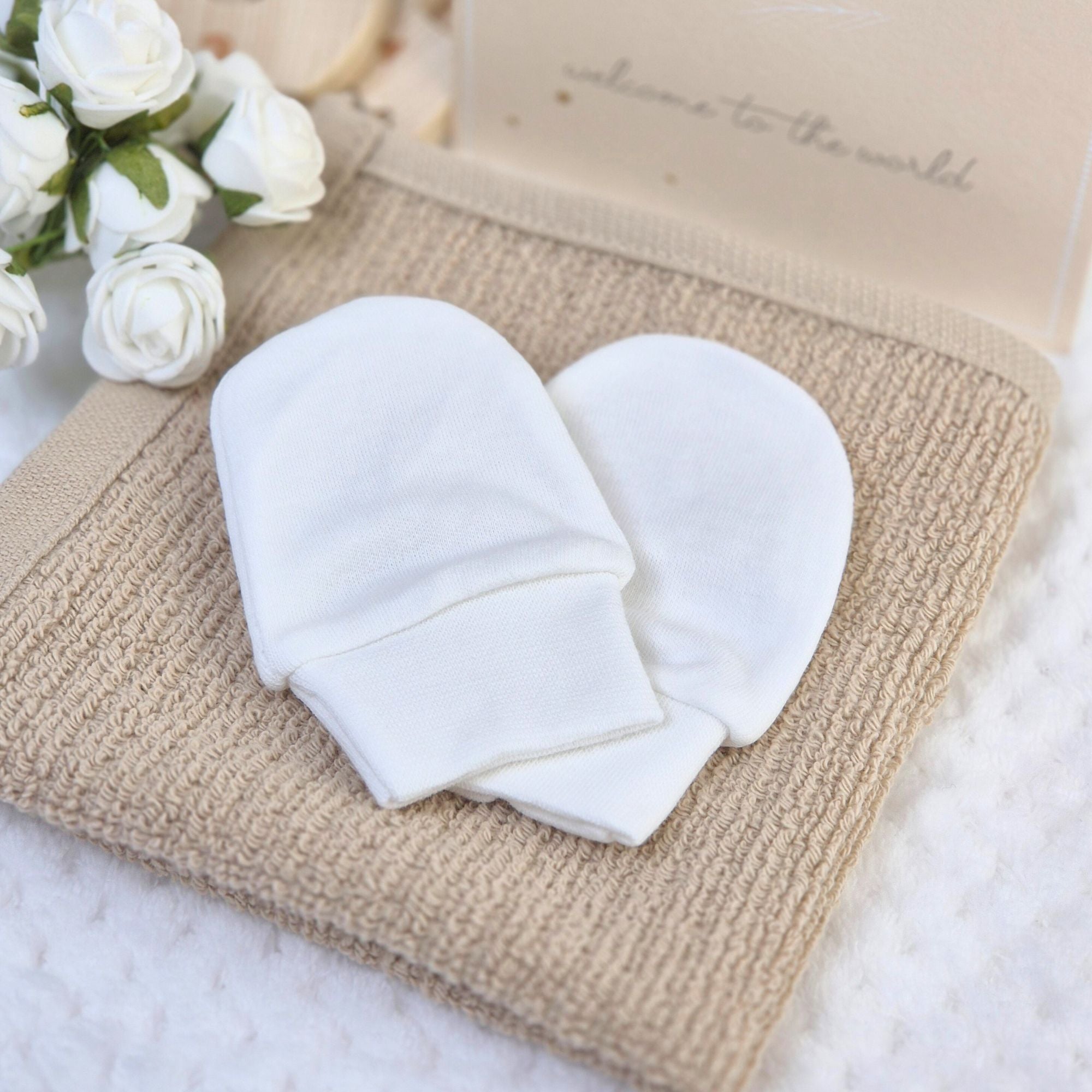 White anti scratch baby mittens for keeping newborn baby hands safe and faces scratch free. 100% cotton.