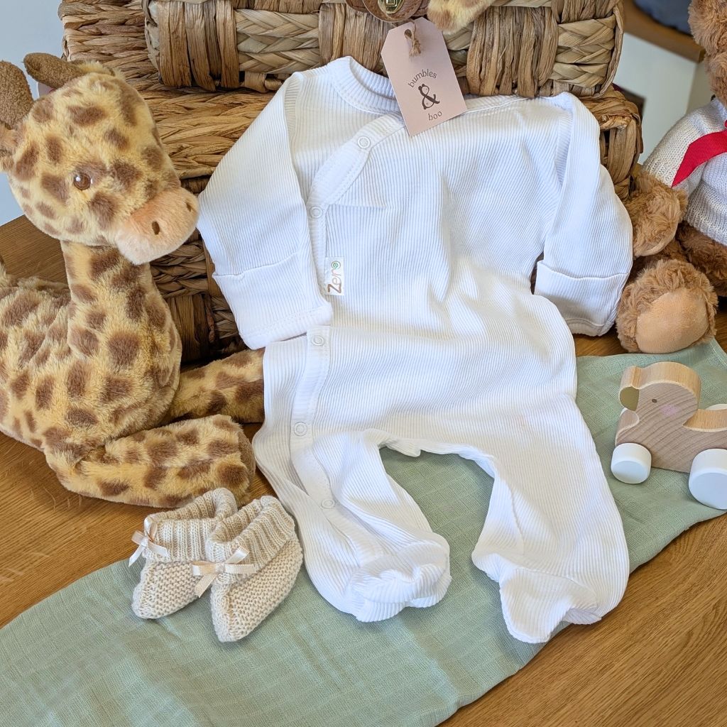 White baby sleepsuit in soft cotton and made from recycled materials.
