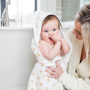 White baby bath towel made of terry towelling cotton wiht a rainbow pattern and hood