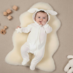 A white baby sleepsuit baby grow with white bunny ears on the hood
