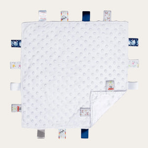 White baby comforter with taggie ribbons.