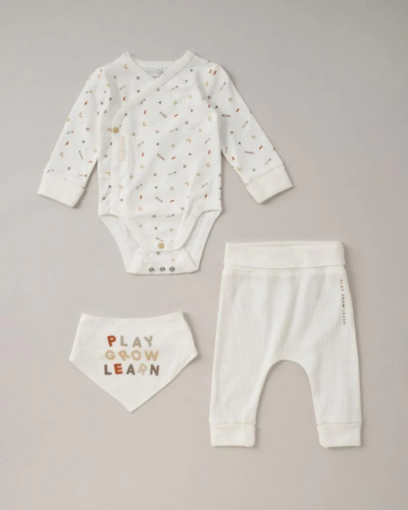 3 piece white baby outfit set containing a long-sleeved bodysuit, trousers and bib reading 'PLAY GROW LEARN'