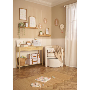 Wooden learning clock on a nursery floor beside an alphabet board in a styled room