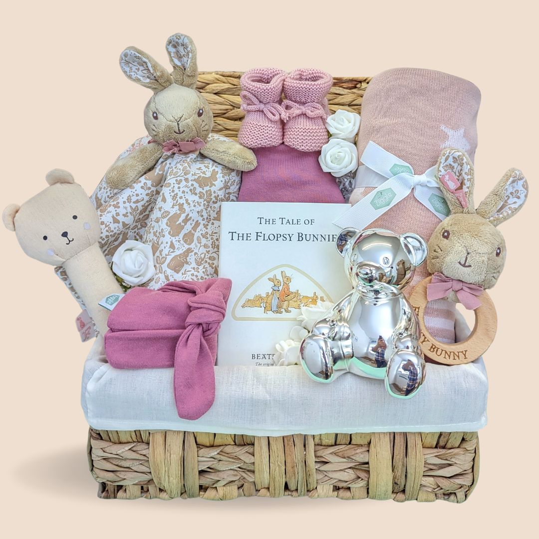 Baby girl hamper basket with flopsy bunny comforter and rattle. Also includes blanket, book, money box and hat.