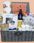 Baby shower gifts hamper basket with presents including chocolates, baby scan frame, body lotion and hedgehog soft toy for baby.