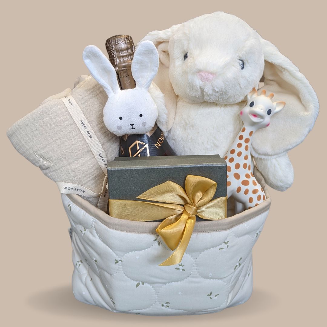 baby shower gifts basket with bunny soft toy, sophie la girafe teething toy, muslin wrap, chocolates for the parents and wine bottle.