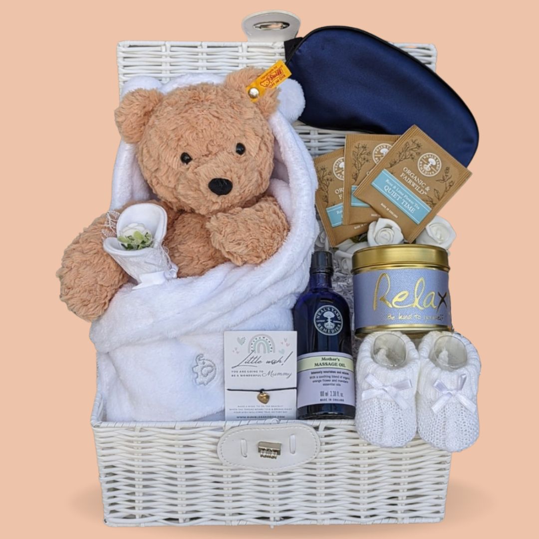 Baby shower gifts for Mum and baby to include teddy, baby clothing and neal's yard products. Packed in a white hamper basket.