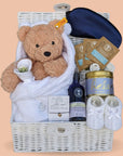 Baby shower gifts for Mum and baby to include teddy, baby clothing and neal's yard products. Packed in a white hamper basket.