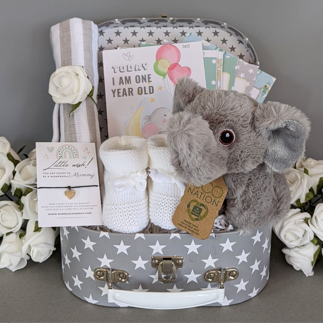 Baby shower hamper gifts with milestone cards and elephant soft toy.