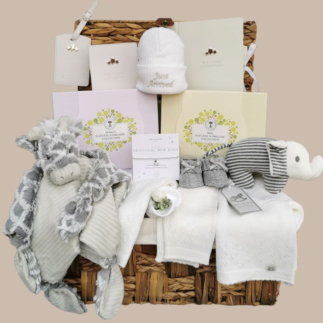 new mum gifts hamper with 2 Neal&#39;s Yard gift boxes, white baby clothes, and soft toys. Topped with a &#39;just arrived&#39; hat.