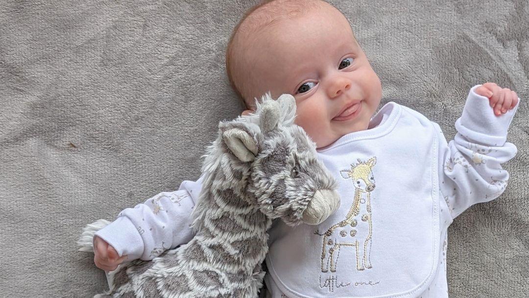 baby with giraffe soft toy