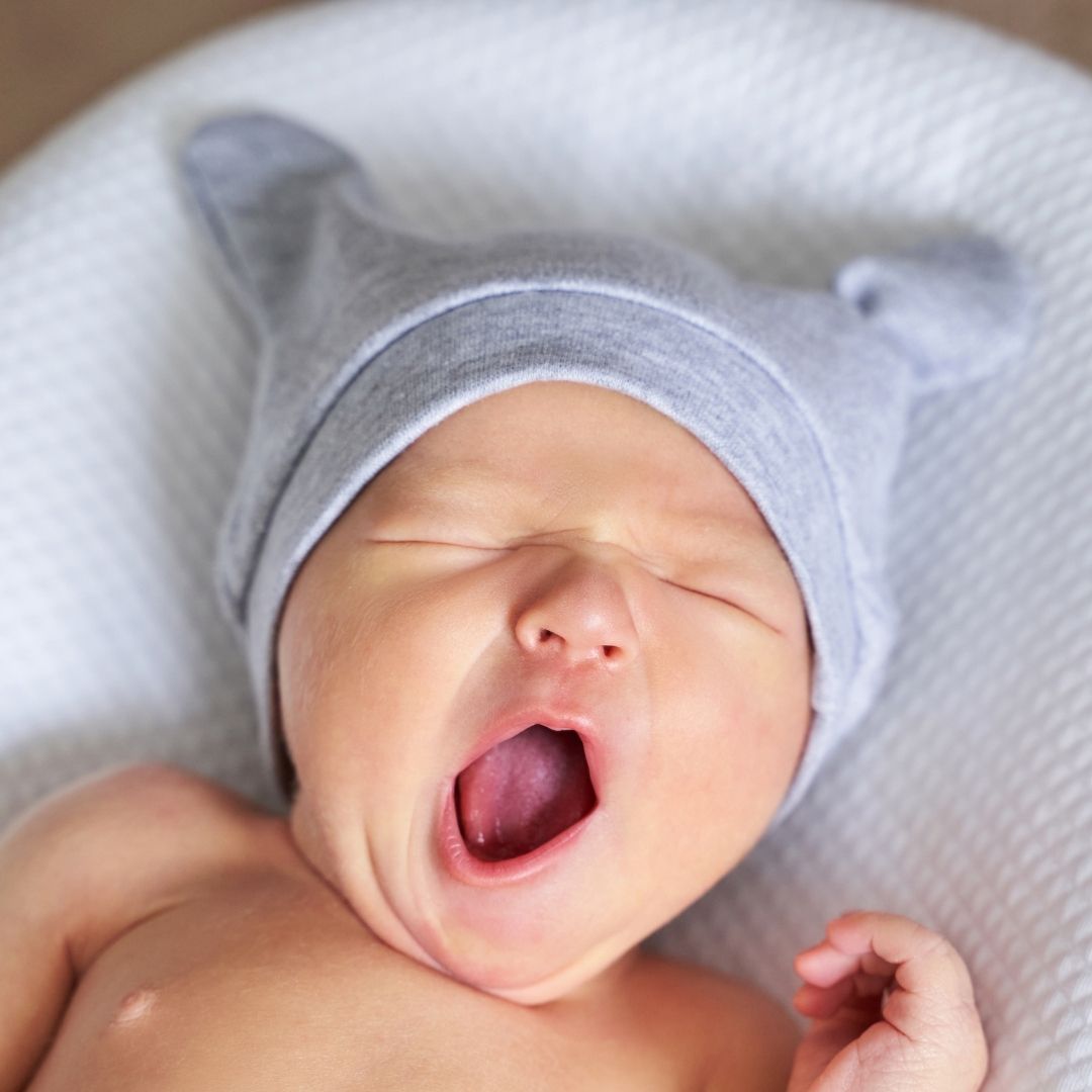 Baby hat on a yawning baby.
