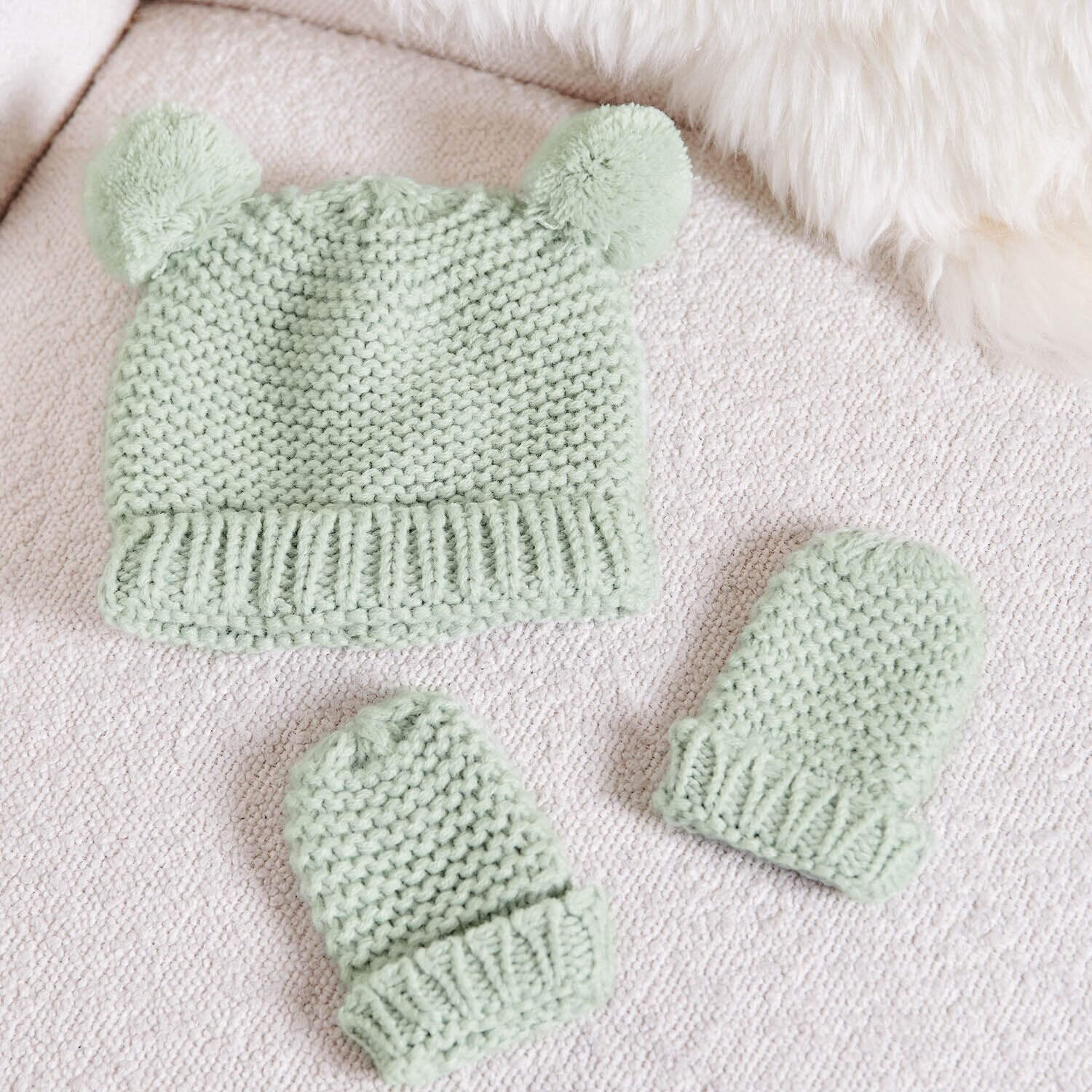 Light sage baby accessories, knitted baby hat with pom poms and matching mittens set for newborn 0–6 months