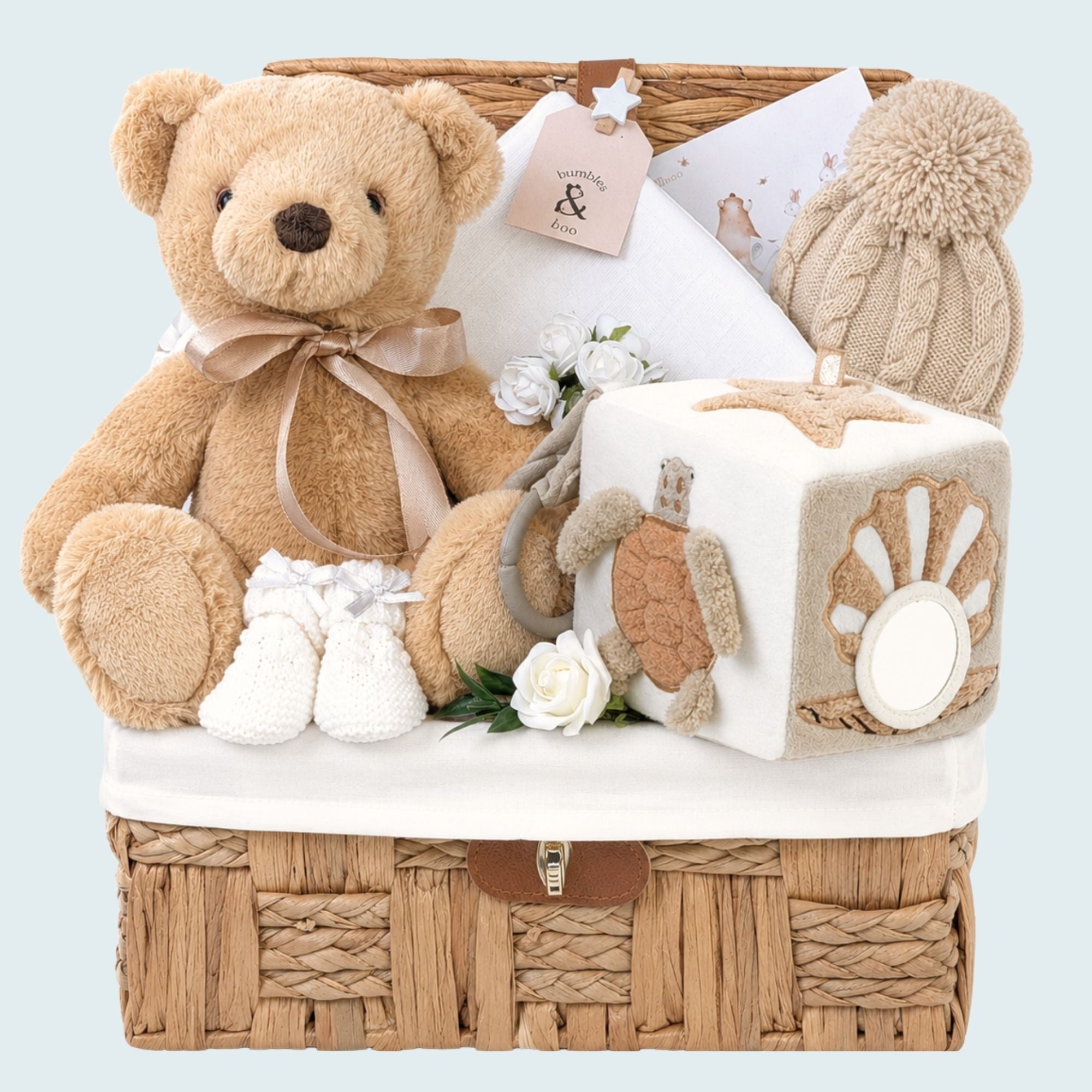 New baby gifts basket filled with presents including teddy bear and  activity cube. Packed in a hamper by Bumbles and Boo.
