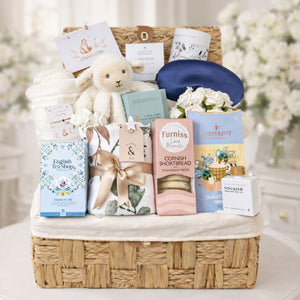 Large mum to be hamper packed with pregnancy gifts presented in a wicker basket with white lamb comforter and sweet treats for mum to be from Bumbles and Boo. 