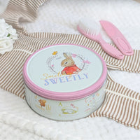Peter rabbit biscuit tin with a pink edge filled with bisuits and which can also be used to keep babies keepsakes safe