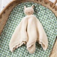Cream baby comforter with toy sheep body attached to a knitted cotton blanket with scalloped edges