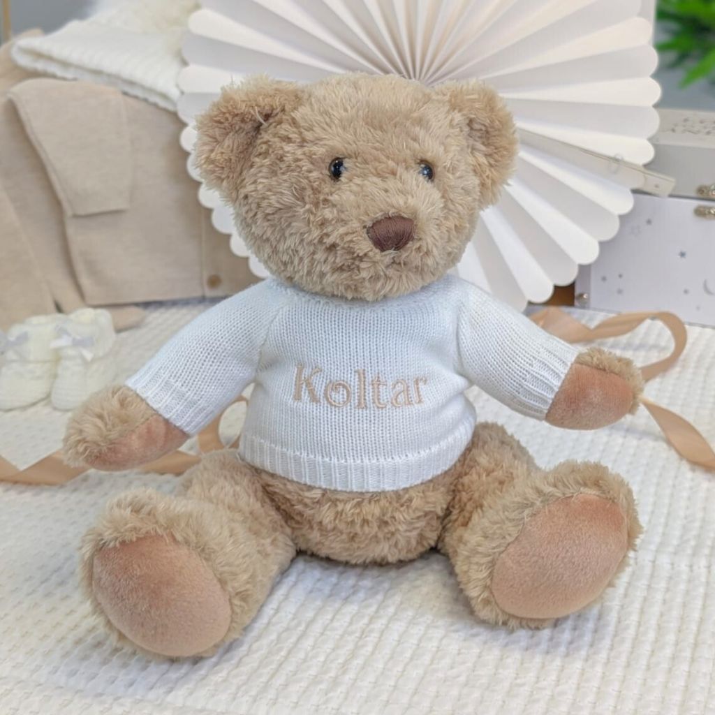 brown teddy bear wearing a white personalised jumper with the name Koltar