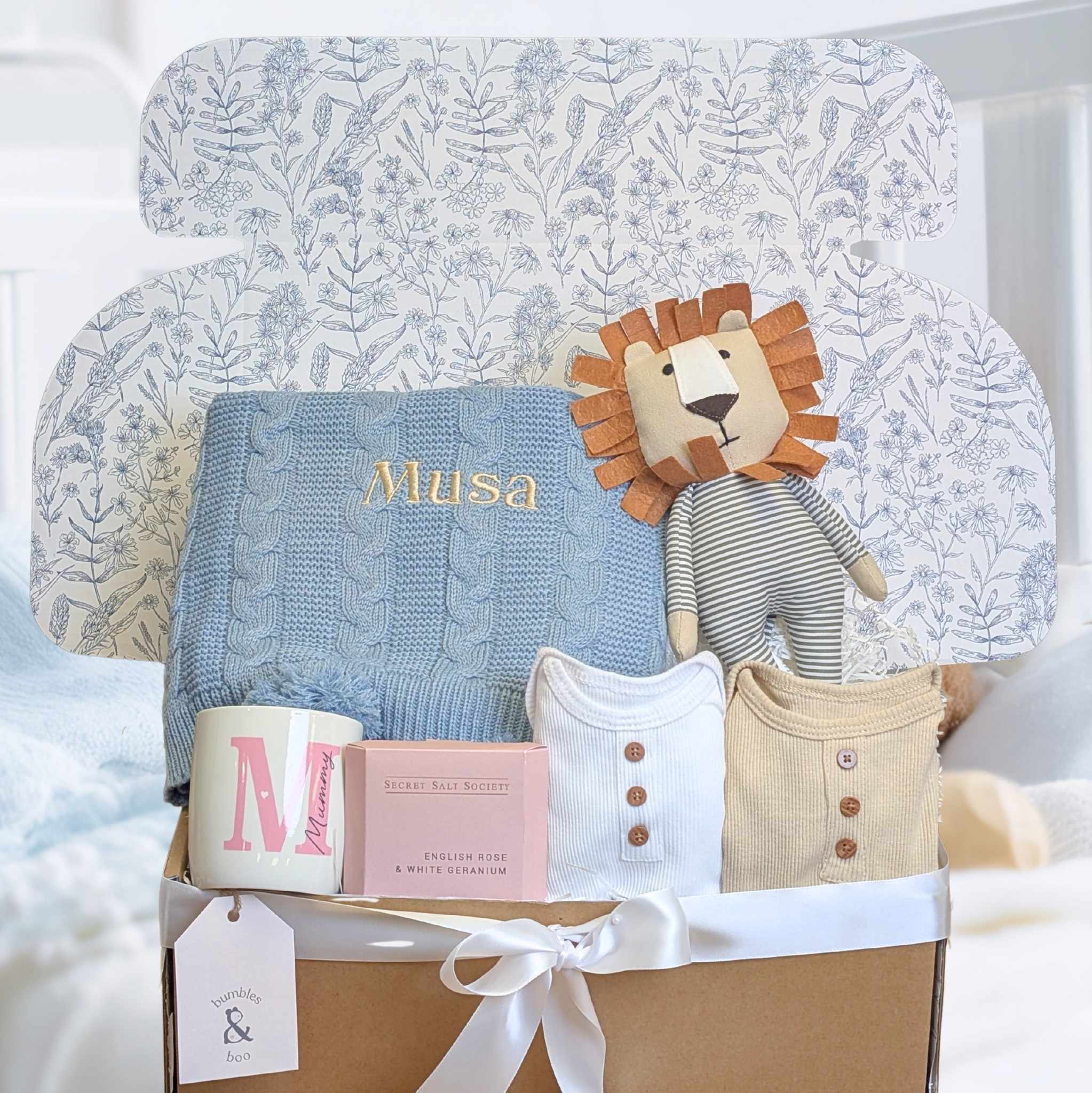 A gift box which has a lion and knit baby blanket in for a new mum