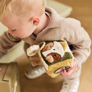 Baby holding neutral Tiny Park soft activity cube toy